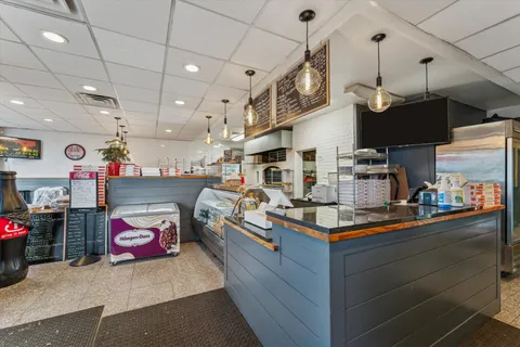 a kitchen filled with stainless steel appliances kitchen island granite countertop a table and chairs