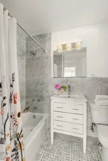 a bathroom with a bathtub sink vanity and toilet
