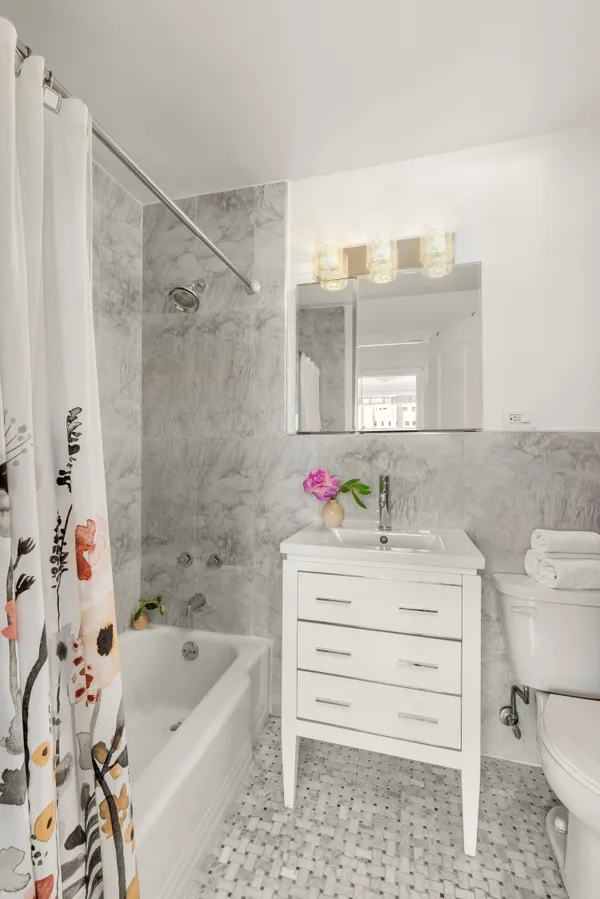 a bathroom with a bathtub sink vanity and toilet