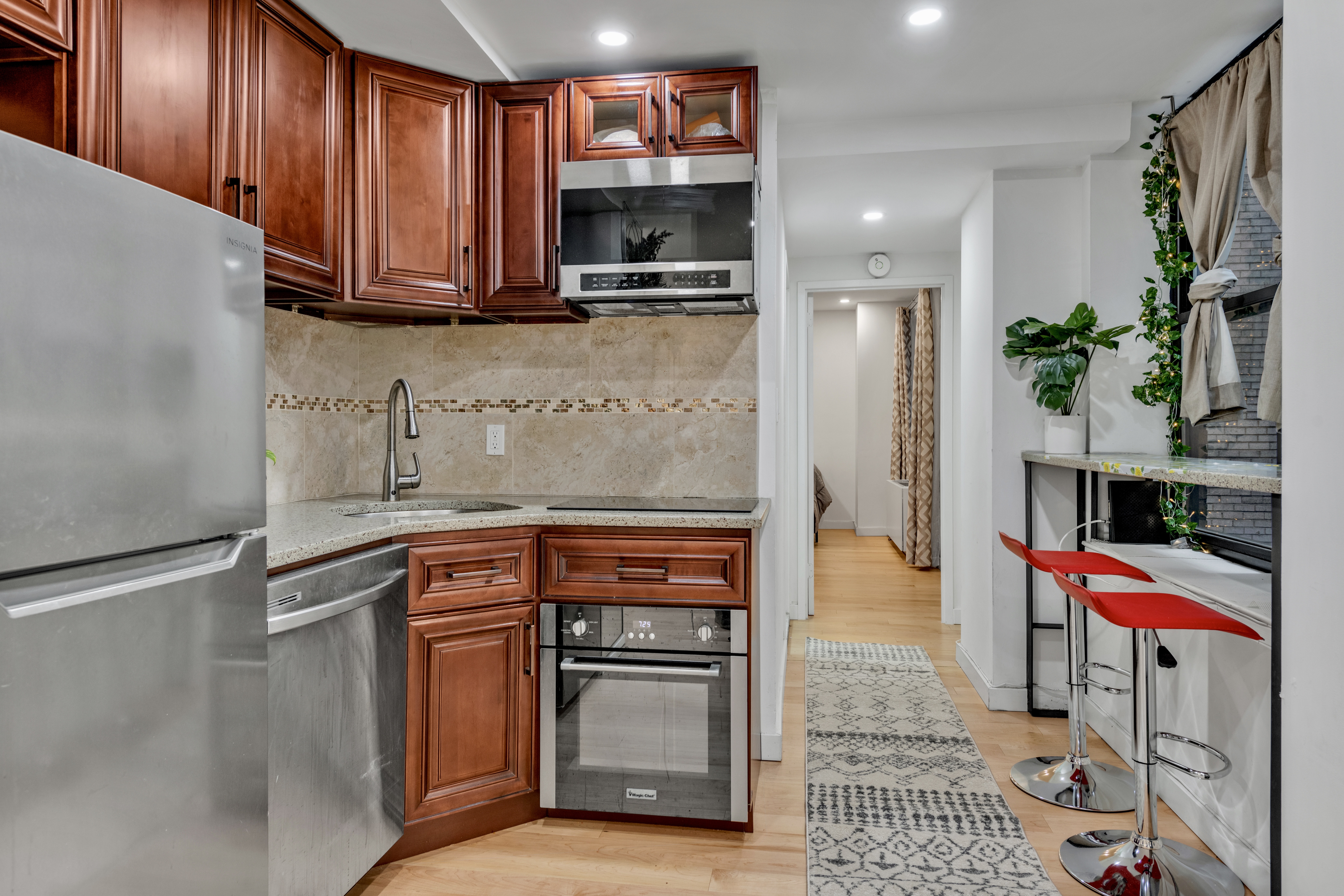 150 West 51st Street, Unit 1528 Manhattan, NY 10019 - Photo 8 of 21 a kitchen with stainless steel appliances granite countertop a refrigerator and a stove top oven