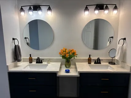 a bathroom with double vanity sinks and a mirror