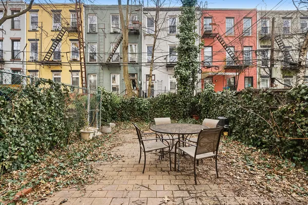 a patio with table and chairs and potted plants