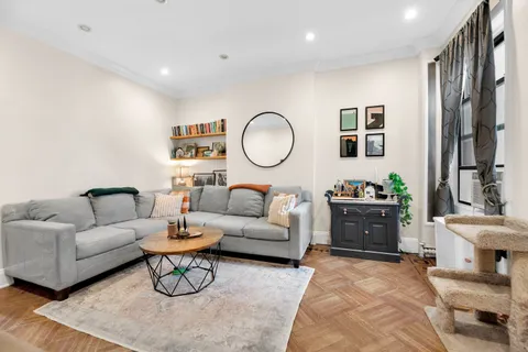 a living room with furniture a rug and a mirror