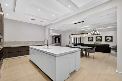 a large white kitchen with a large counter top and stainless steel appliances