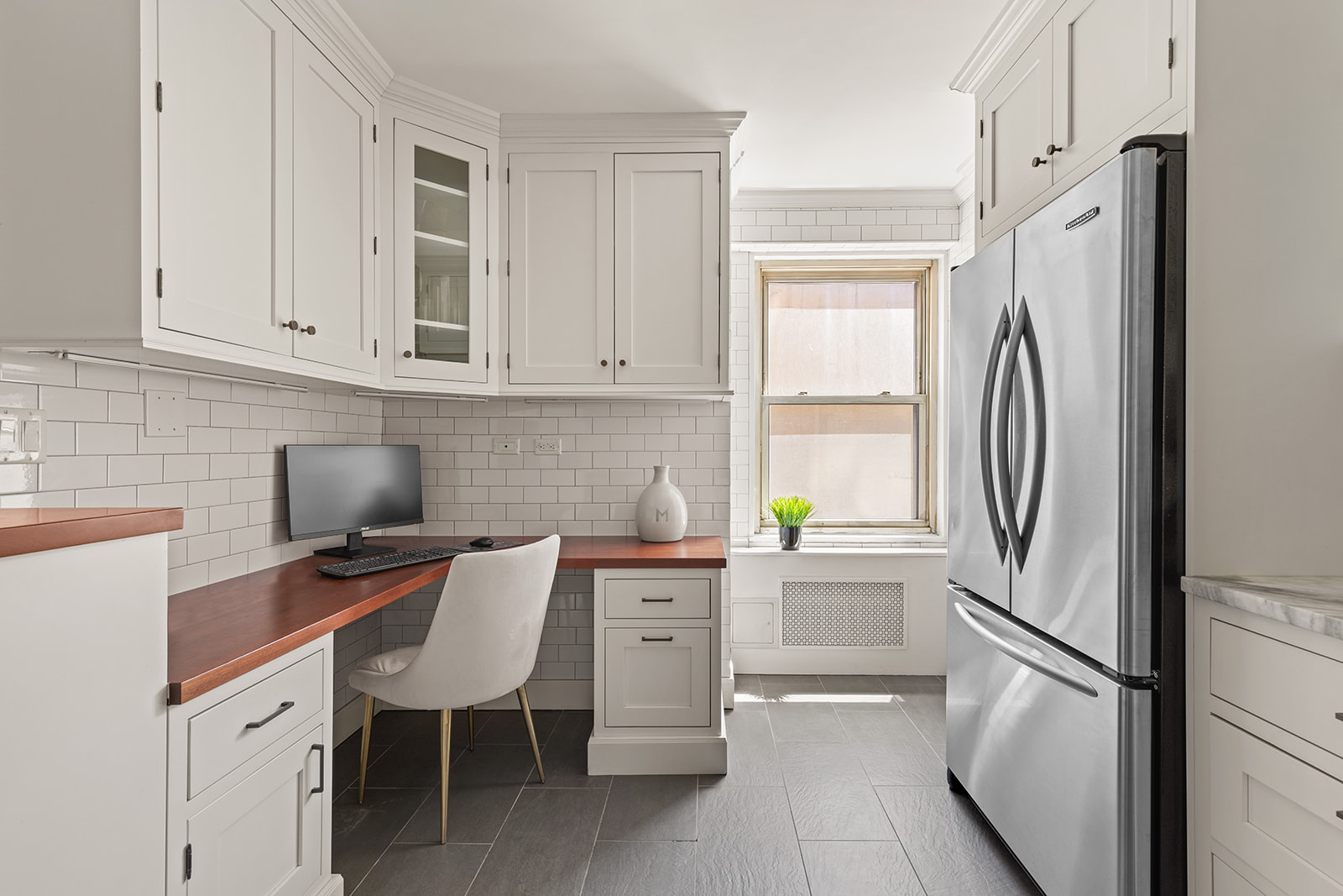 400 East 85th Street, Unit 4L Manhattan, NY 10028 - Photo 4 of 12 a kitchen with stainless steel appliances a refrigerator sink and cabinets