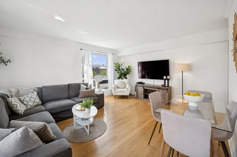 a living room with furniture a flat screen tv and a dining table