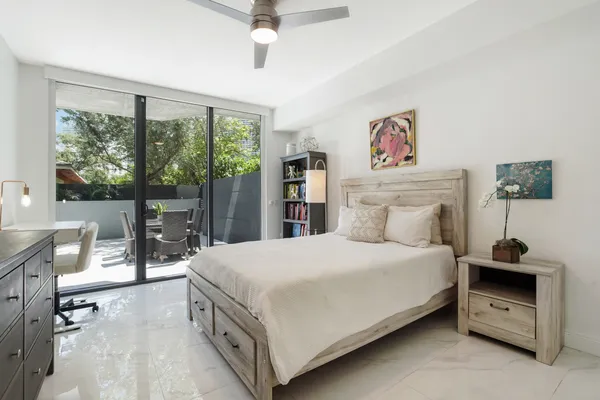 a bedroom with a bed and a large window