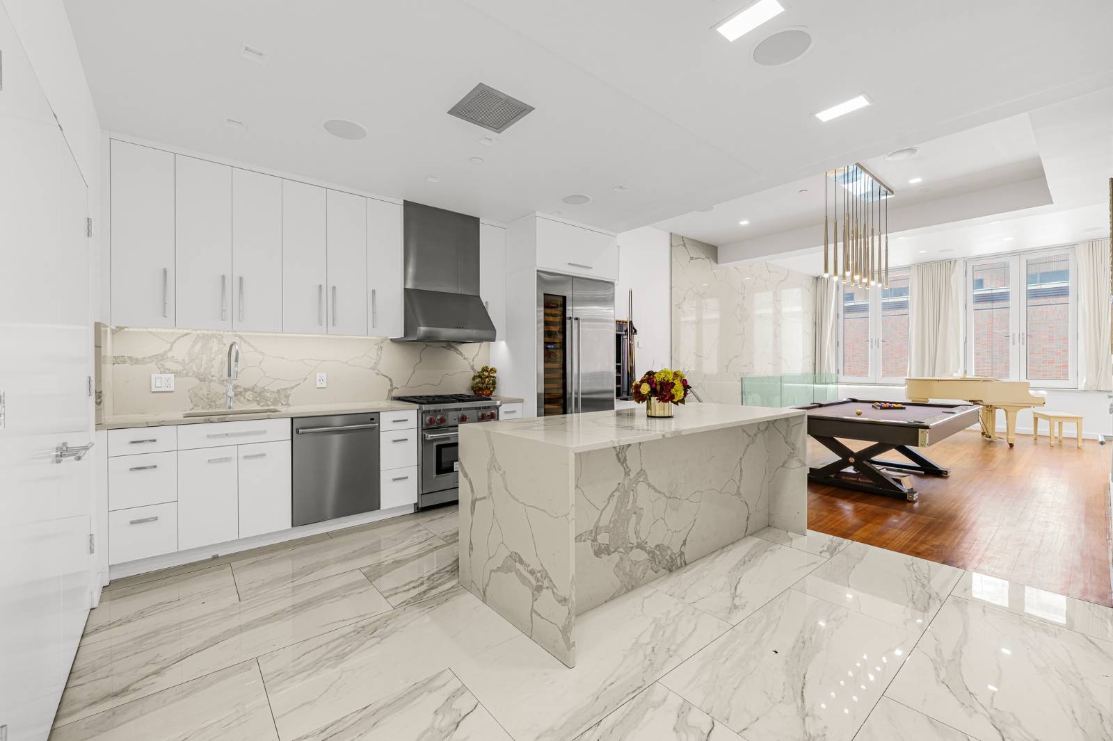 124 East 13th Street, Unit 3 Manhattan, NY 10003 - Photo 7 of 26 a large white kitchen with a stove a sink dishwasher and a refrigerator with wooden floor