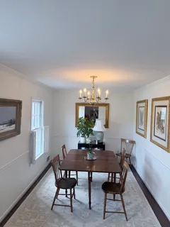 a view of a dining room with furniture and chandelier