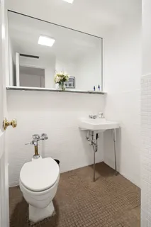 a bathroom with a sink a toilet and a mirror