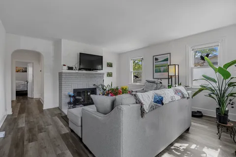 a living room with furniture a flat screen tv and a fireplace