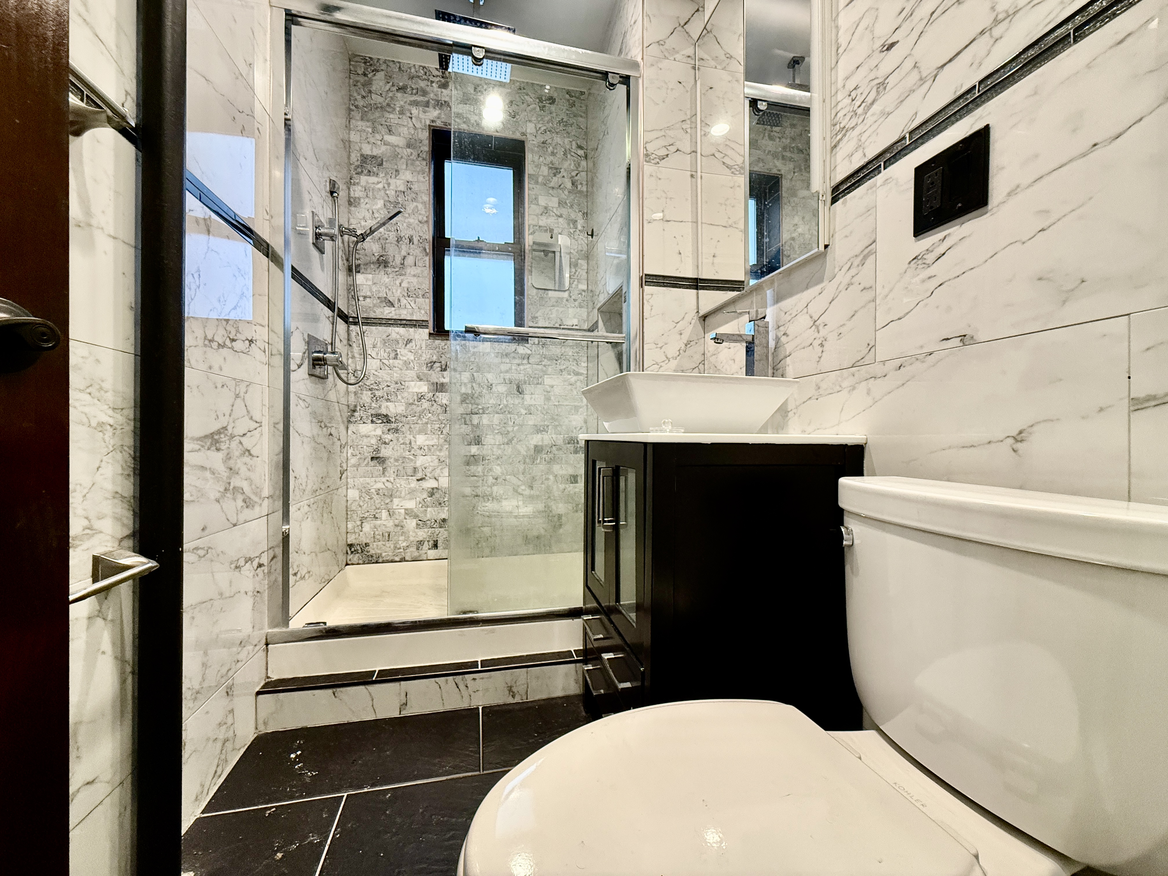 6817 Owls Head Court, Unit 1B Brooklyn, NY 11220 - Photo 5 of 6 a bathroom with a sink a toilet and shower