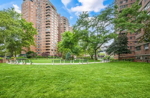 a view of a big building with a big yard and large trees