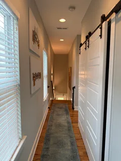 a view of a hallway with wooden floor and staircase
