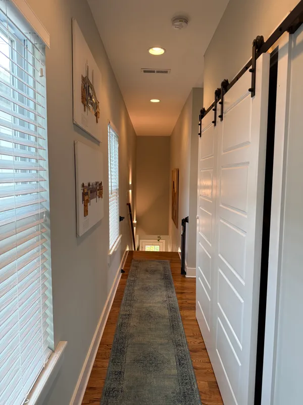 a view of a hallway with wooden floor and staircase