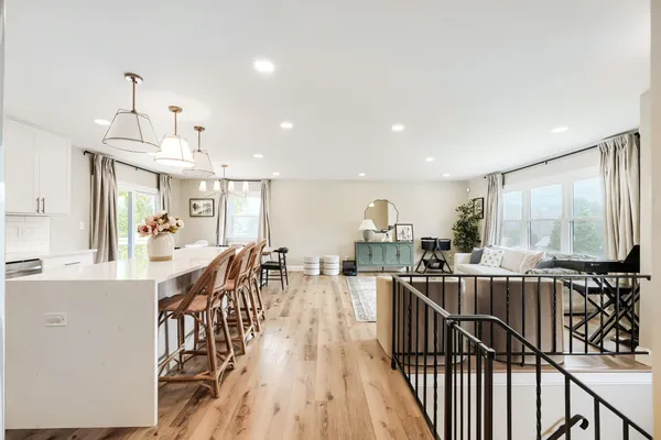 a view of a dining room and livingroom with furniture wooden floor a chandelier