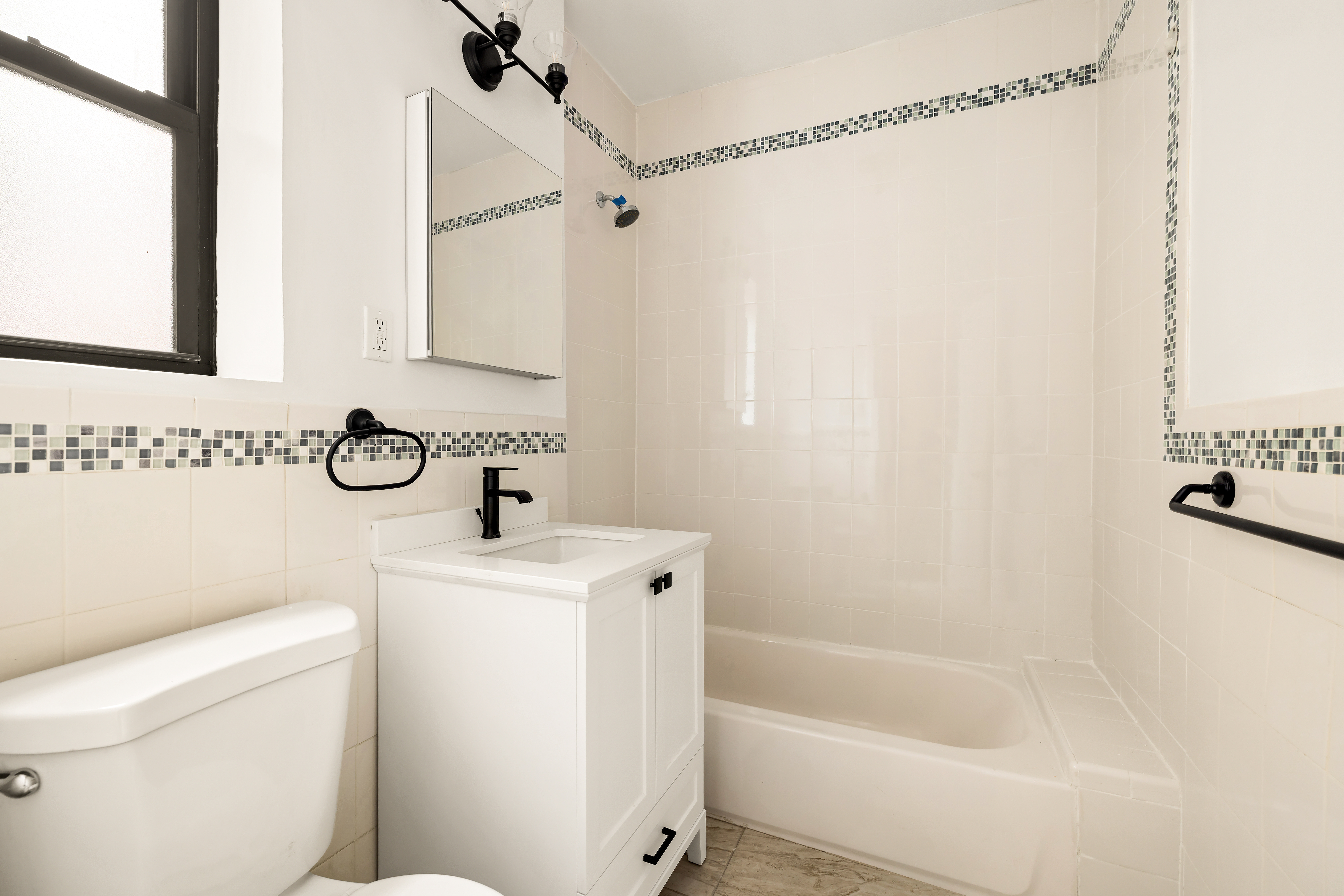 47-39 40th Street, Unit 2G Queens, NY 11104 - Photo 9 of 15 a bathroom with a sink a toilet and a bathtub