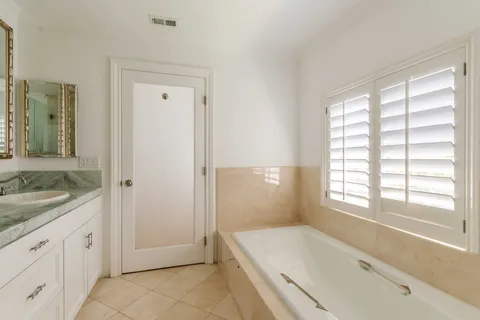 a spacious bathroom with a granite countertop tub sink and mirror