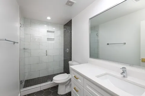 a bathroom with a sink a toilet and shower