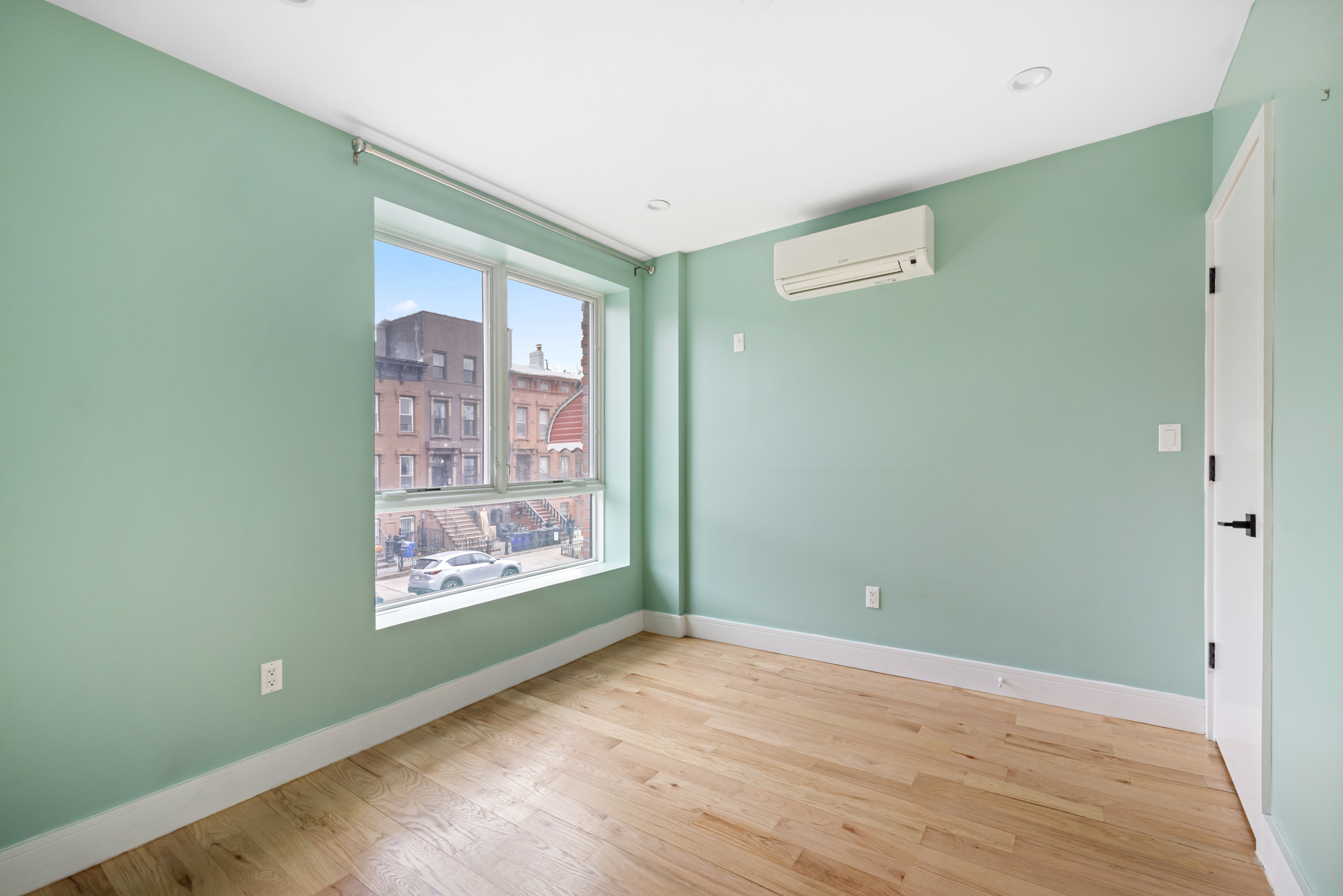 479 Monroe Street, Unit 2F Brooklyn, NY 11221 - Photo 4 of 6 a view of an empty room with window and wooden floor