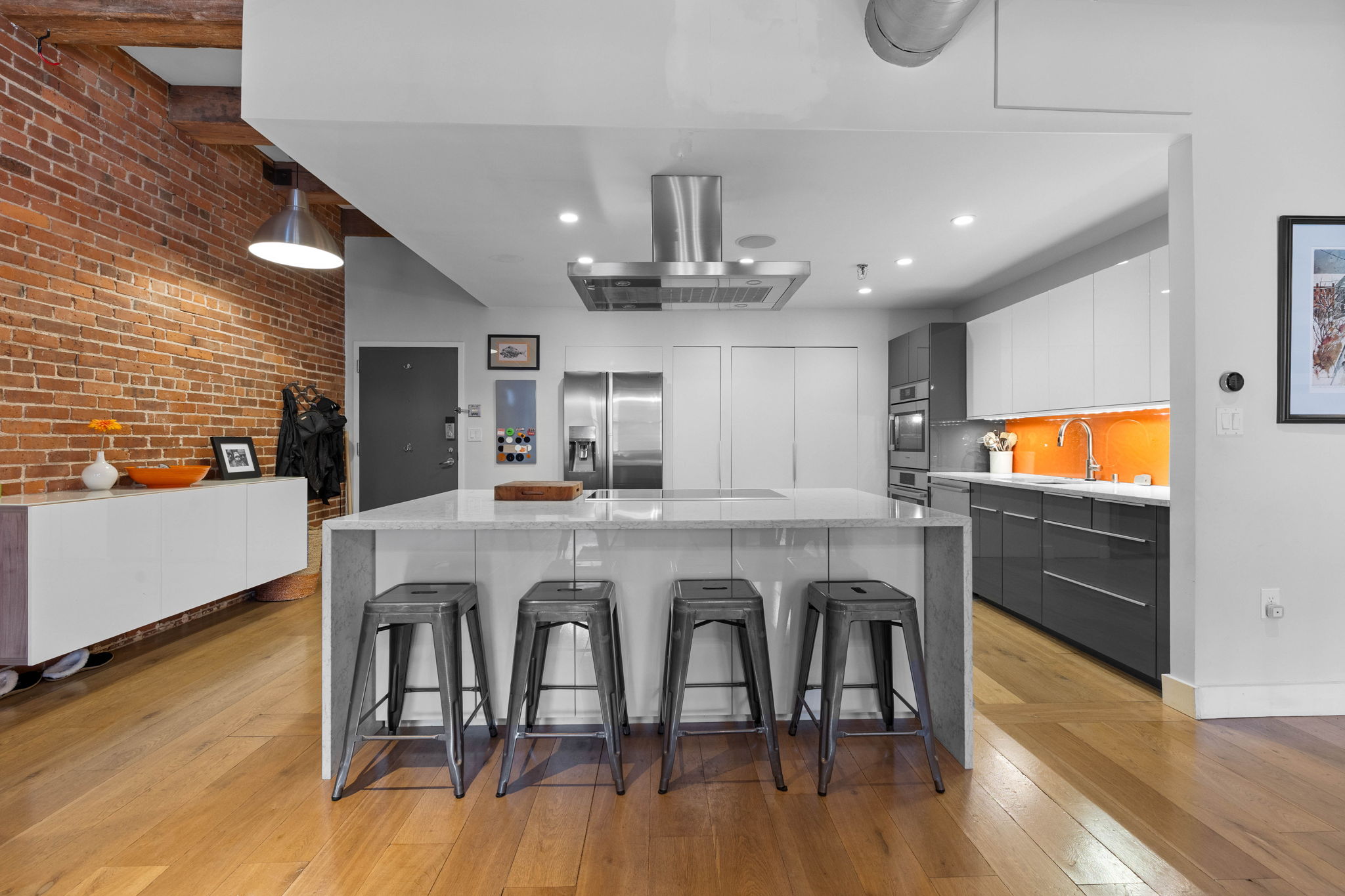 33 Sleeper Street, Unit 307 Boston, MA 02210 - Photo 5 of 15 a kitchen with stainless steel appliances granite countertop a dining table chairs refrigerator and microwave