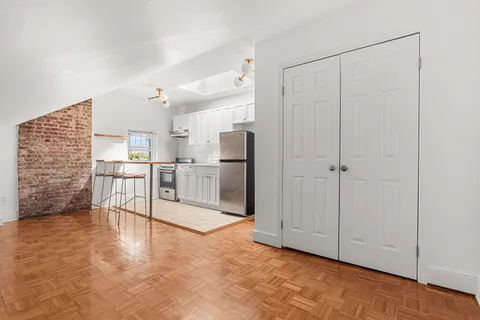 a view of kitchen with furniture and refrigerator