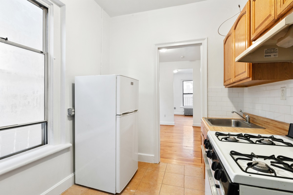 9 Spring Street, Unit 24 Manhattan, NY 10012 - Photo 3 of 8 a kitchen with stainless steel appliances granite countertop a refrigerator and a stove