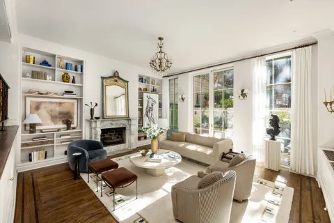 a living room with furniture fireplace and a large window