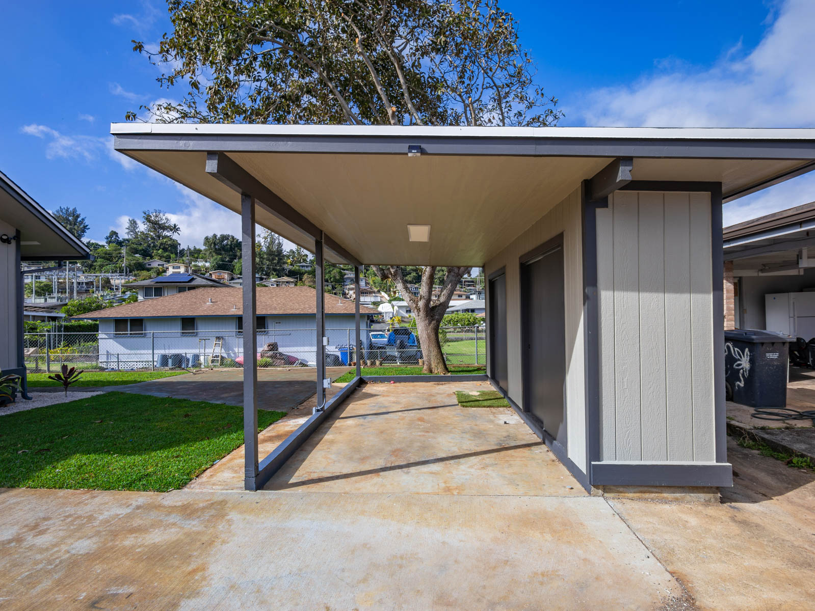 45-561 Paleka Road, Unit C Kaneohe, HI 96744 - Photo 26 of 27 a view of a patio with a table and chairs under an umbrella with a small yard