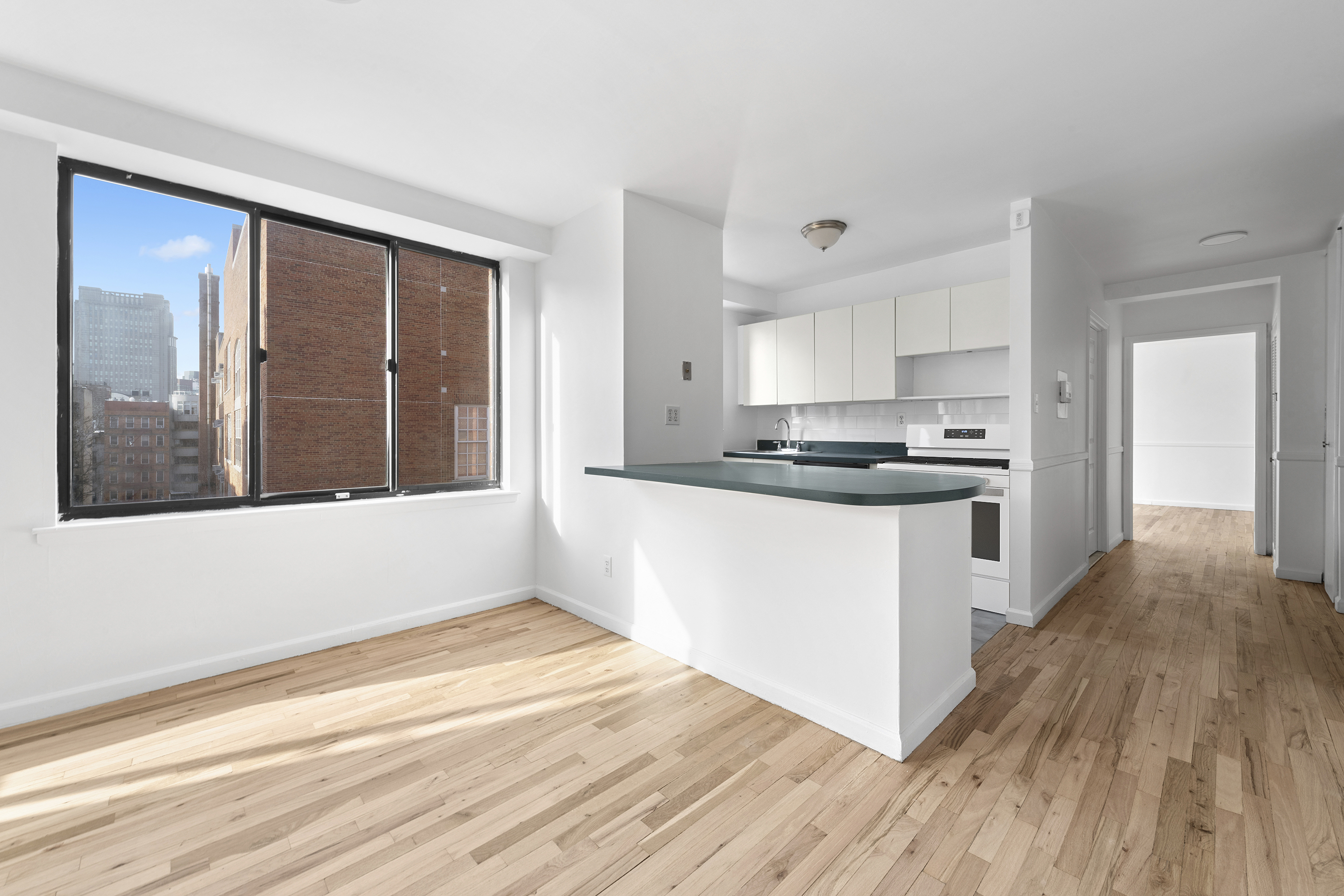 179 Grand Street, Unit 6G Manhattan, NY 10013 - Photo 3 of 8 a kitchen with stainless steel appliances granite countertop a stove and a refrigerator