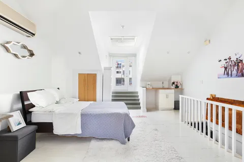 a living room with furniture and a baby crib