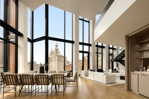 a view of a living room with furniture and floor to ceiling windows