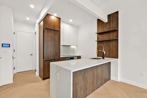 a kitchen that has a sink a refrigerator and cabinets