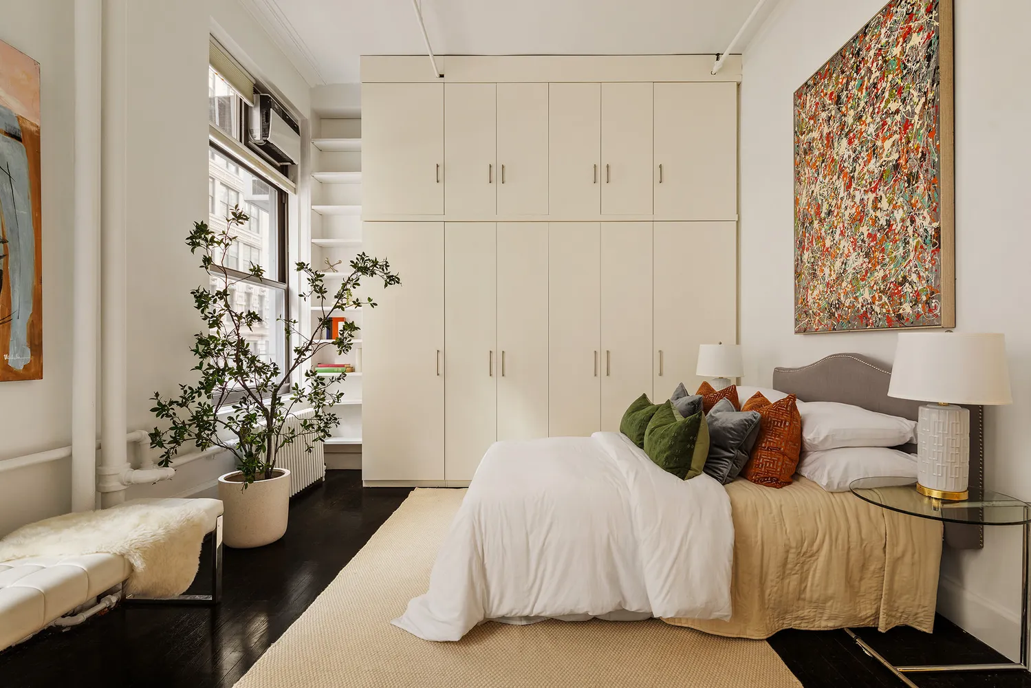 a bedroom with a bed and a potted plant