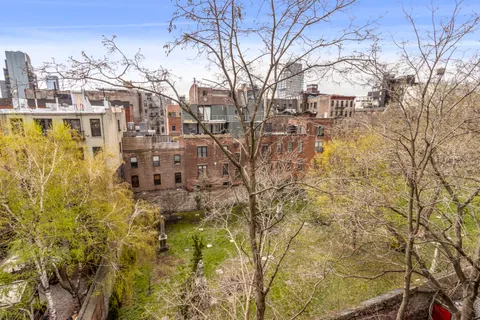 a view of residential houses with yard and city view