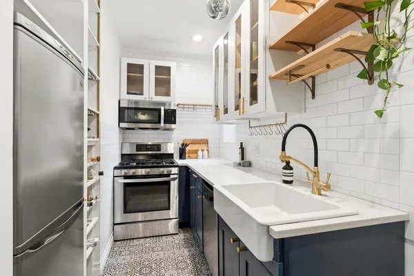 a kitchen with stainless steel appliances a stove a sink and a refrigerator
