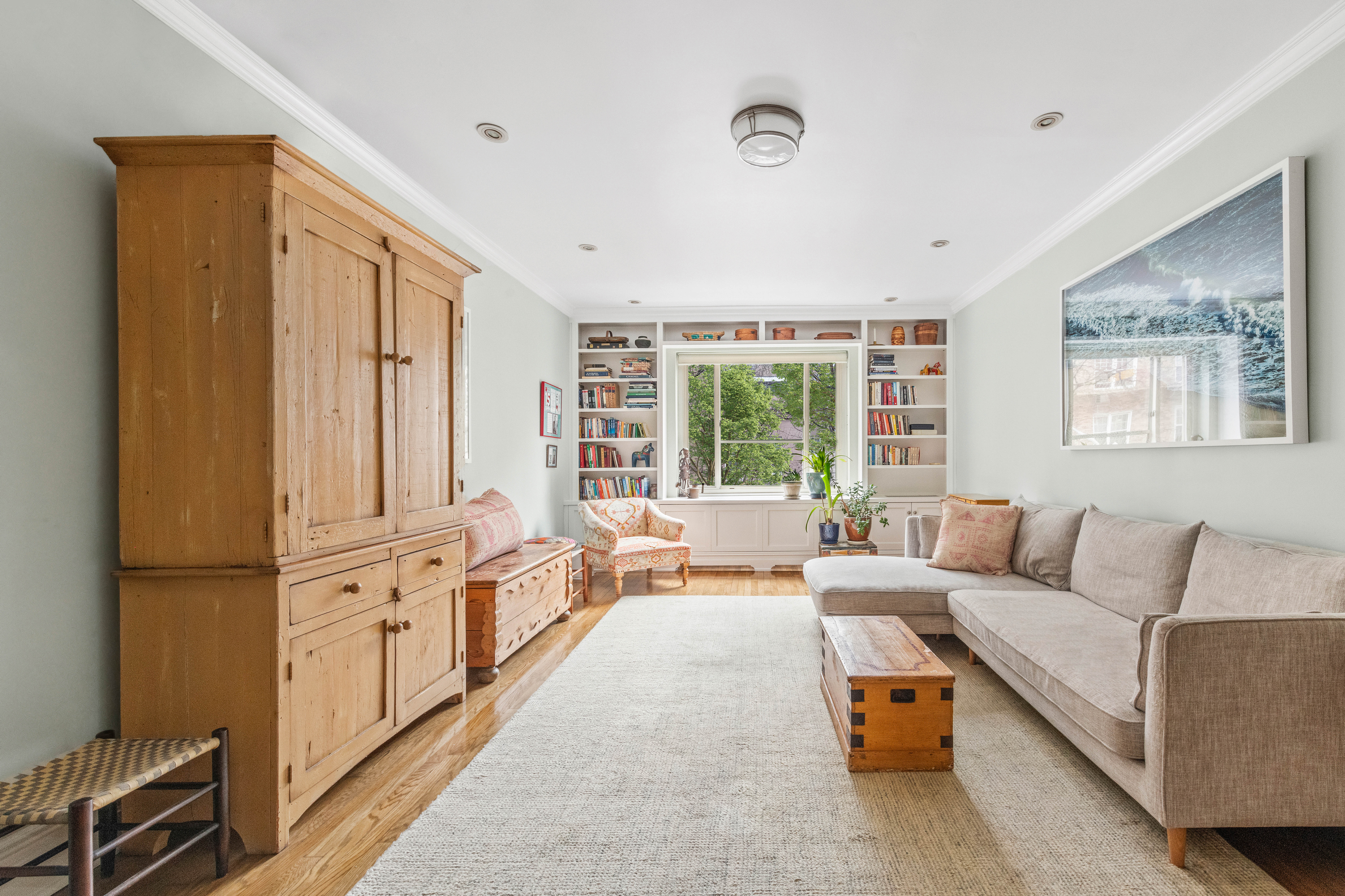 a living room with furniture large windows and wooden floor