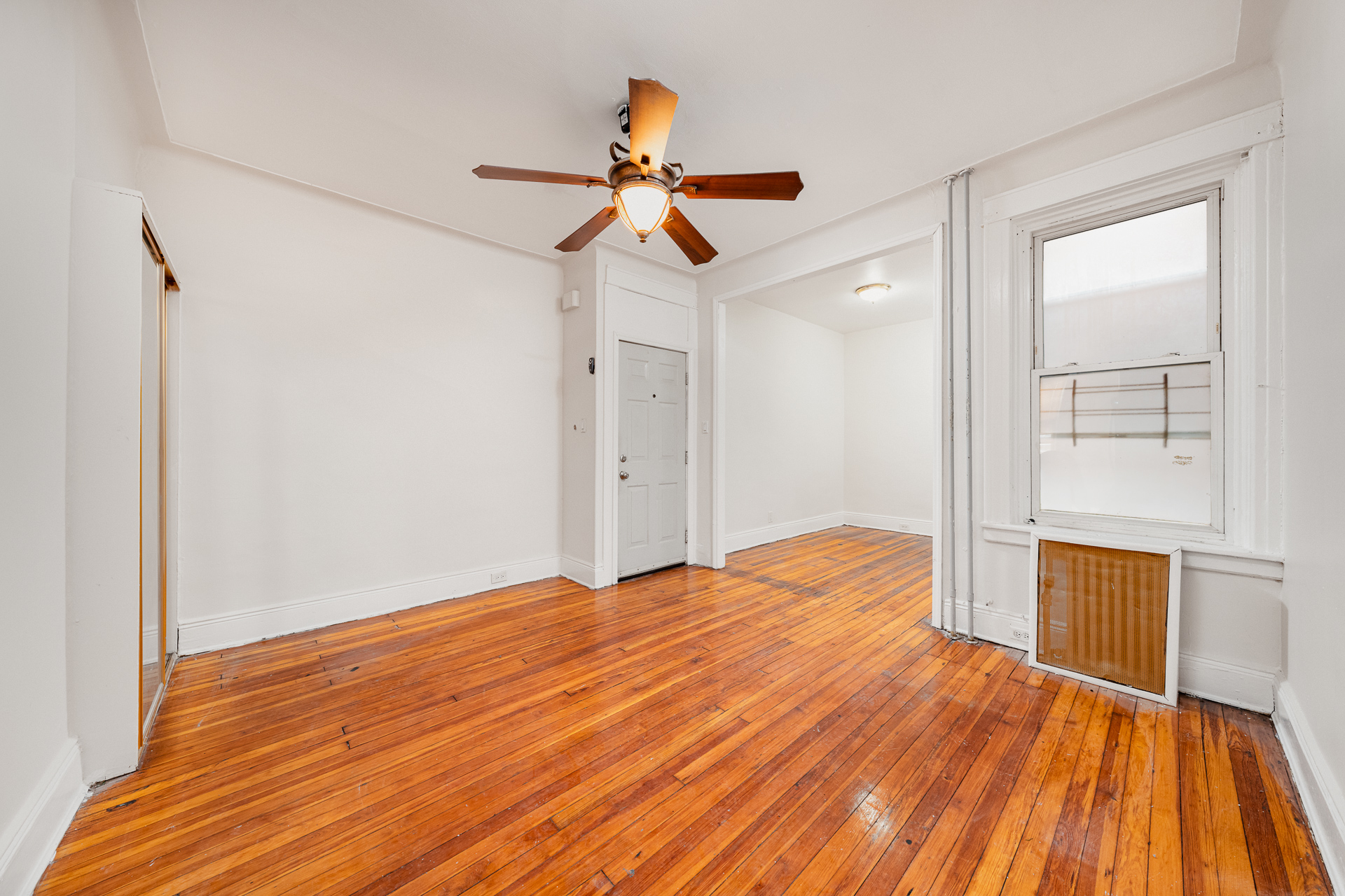 70-03 66th Street, Unit 1L Queens, NY 11385 - Photo 4 of 8 a bedroom with a bed and wooden floor