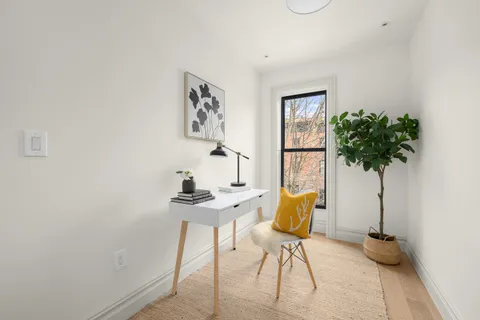 a view of a workspace with furniture and a potted plant