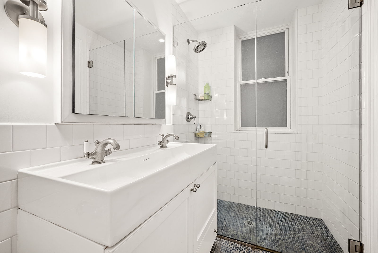 152 West 58th Street, Unit 6CD Manhattan, NY 10019 - Photo 7 of 9 a bathroom with a sink a toilet and a mirror