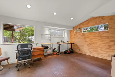 a view of a workspace with furniture and a window