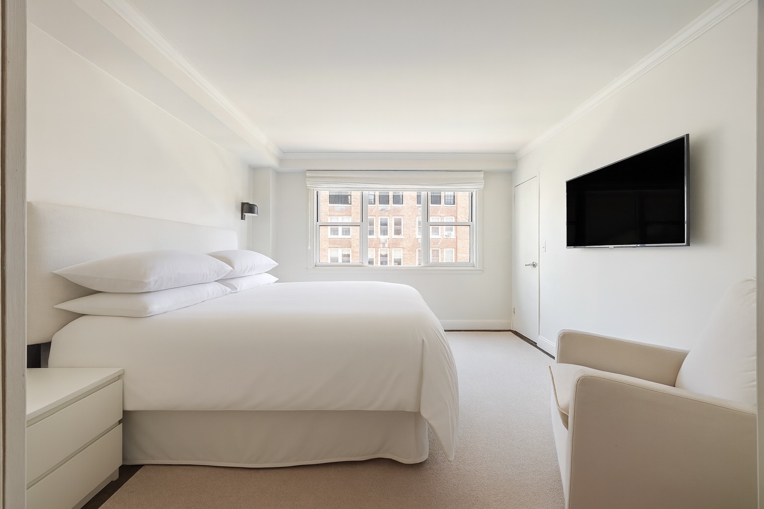 123 East 75th Street, Unit 6B Manhattan, NY 10021 - Photo 7 of 13 a bedroom with a bed a flat screen tv and a window