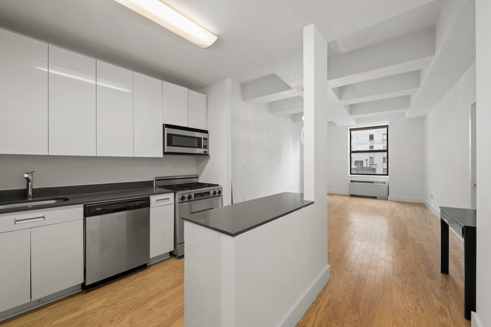 99 John Street, Unit 1711 Manhattan, NY 10038 - Photo 5 of 14 a kitchen with granite countertop a stove top oven and sink