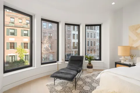 a bedroom with furniture and a large window