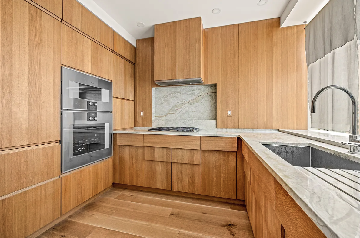 120 Riverside Boulevard, Unit 10W Manhattan, NY 10069 - Photo 4 of 13 a kitchen with stainless steel appliances granite countertop a sink and cabinets with wooden floor