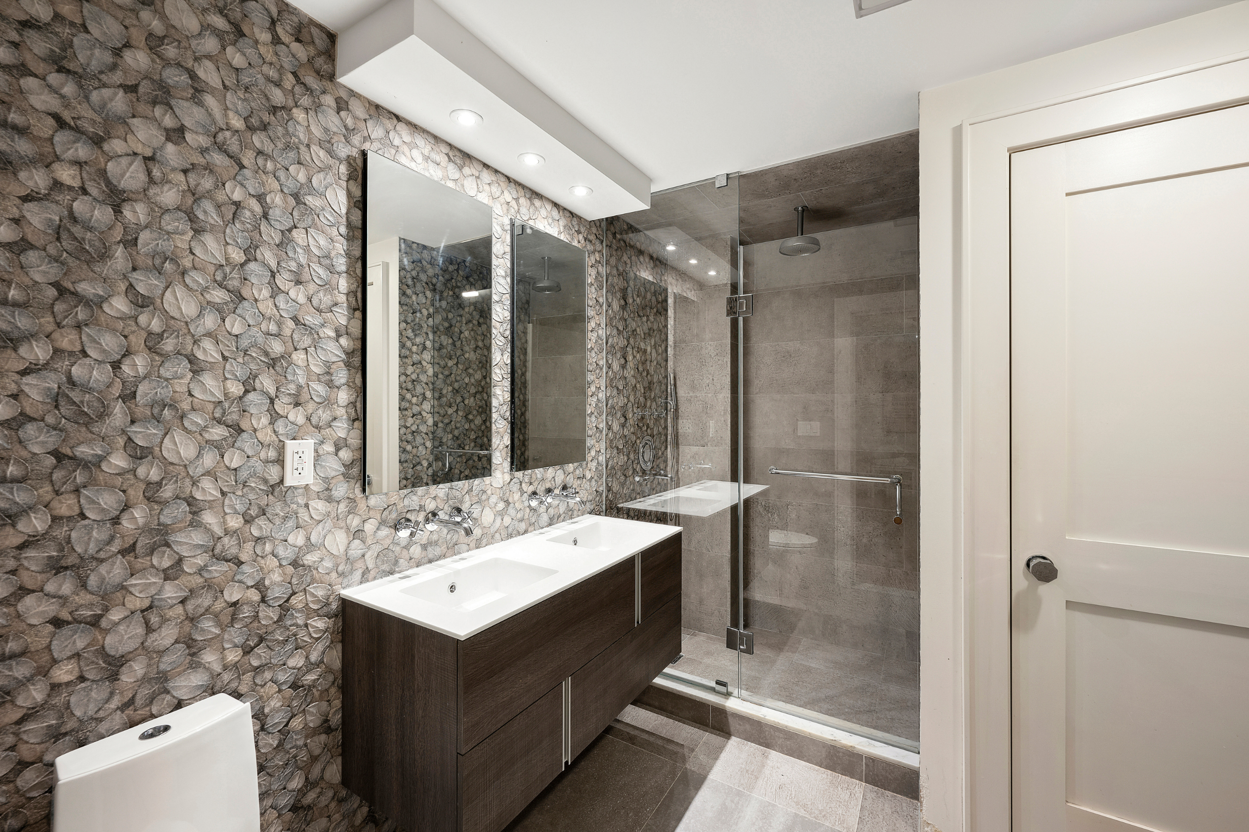 170 East 88th Street, Unit 1C Manhattan, NY 10128 - Photo 15 of 16 a bathroom with a sink mirror and a shower