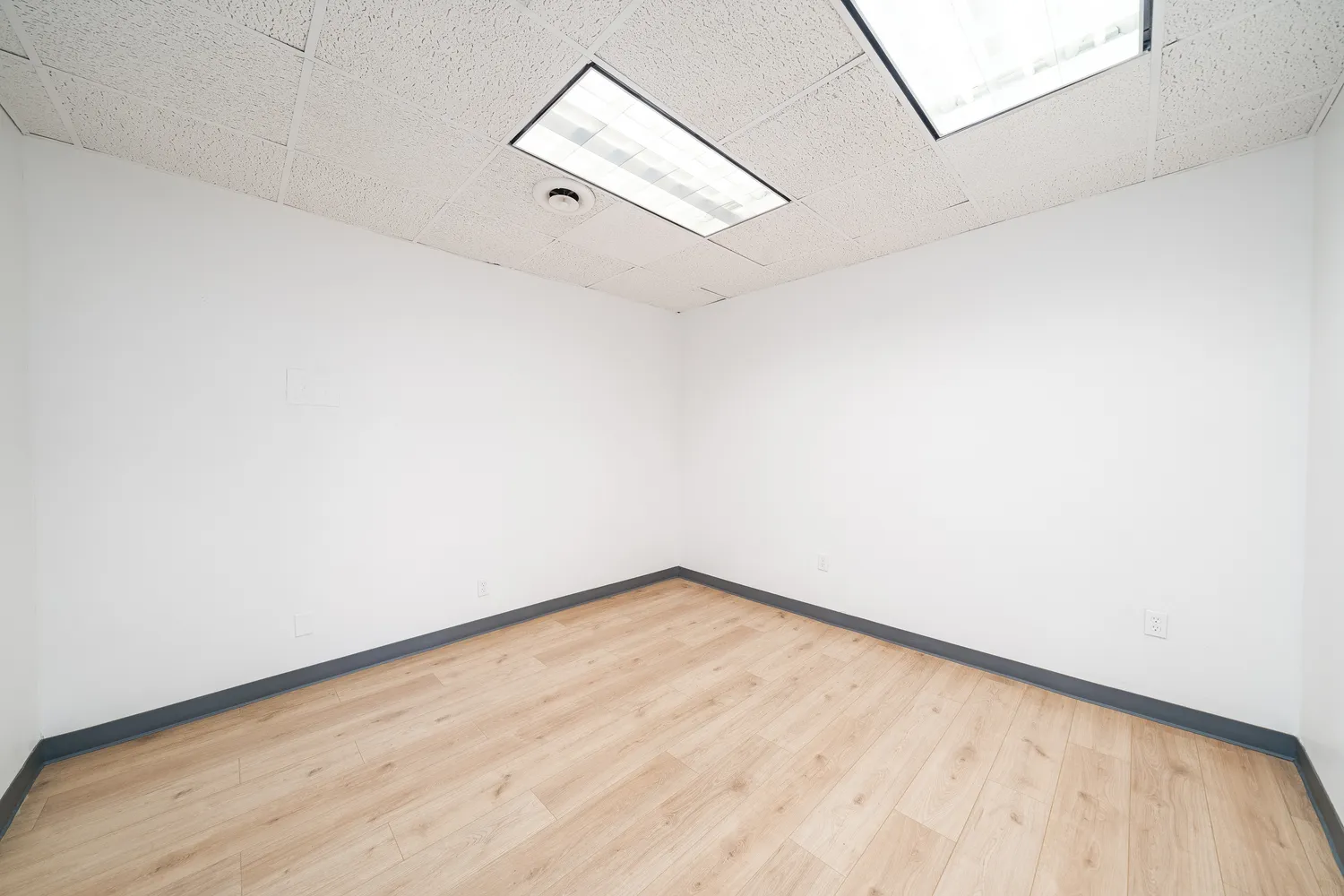 a view of a room with wooden floor and white walls