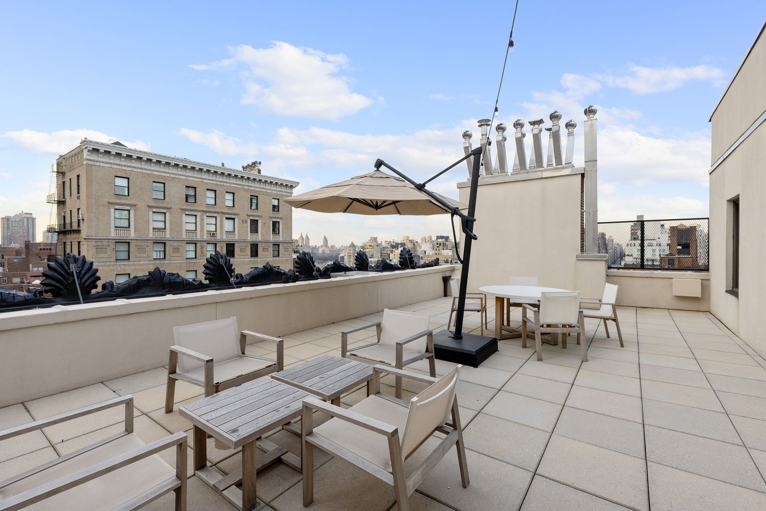 a view of roof deck with dining table and chairs