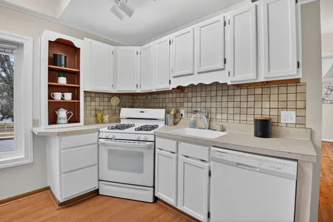 a kitchen with white cabinets and white appliances
