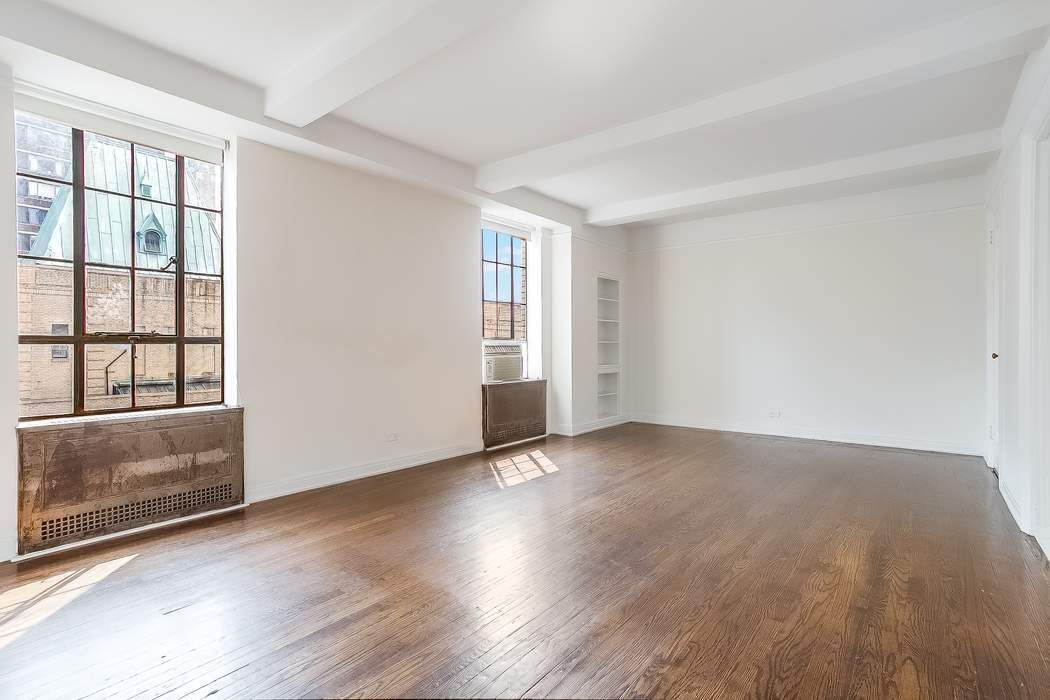 340 West 57th Street, Unit 14E Manhattan, NY 10019 - Photo 6 of 13 an empty room with wooden floor and windows